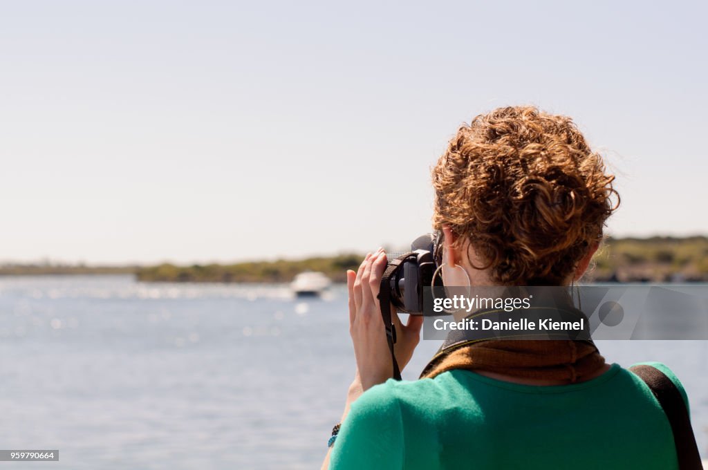 Young woman taking photo of lake