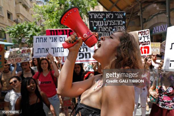Israeli activists chant slogans, as they carry placards, during the 7th annual SlutWalk march through central Jerusalem on May 18 to protest rape...