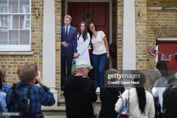 Royal fans and tourists take photos as a woman poses with a cardboard cut-out, near Windsor Castle, a day ahead of the wedding of Prince Harry and...