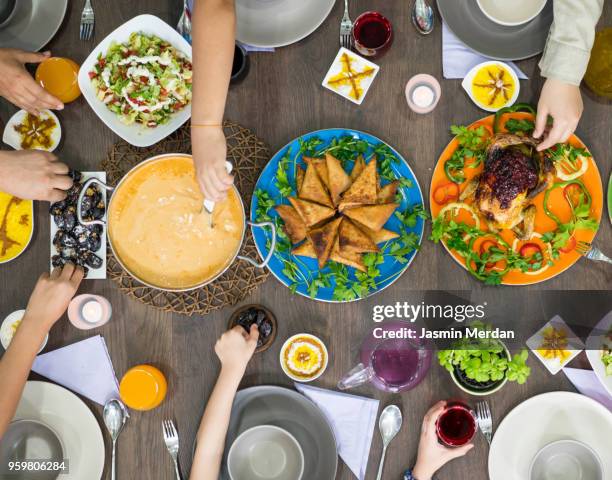 gathering together for family dinner - arabische familie stock-fotos und bilder