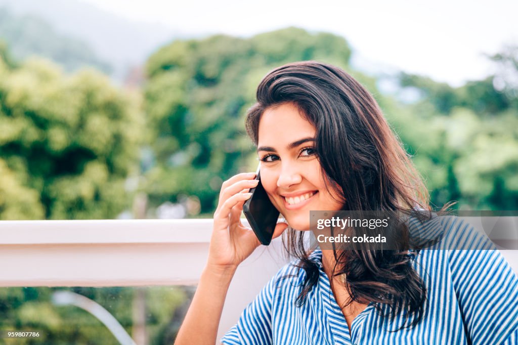 Mujer joven haciendo una llamada a teléfono celular