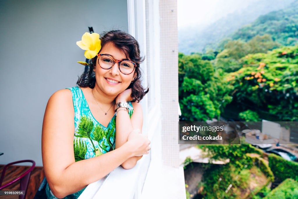 Young woman with flower on her her at the window