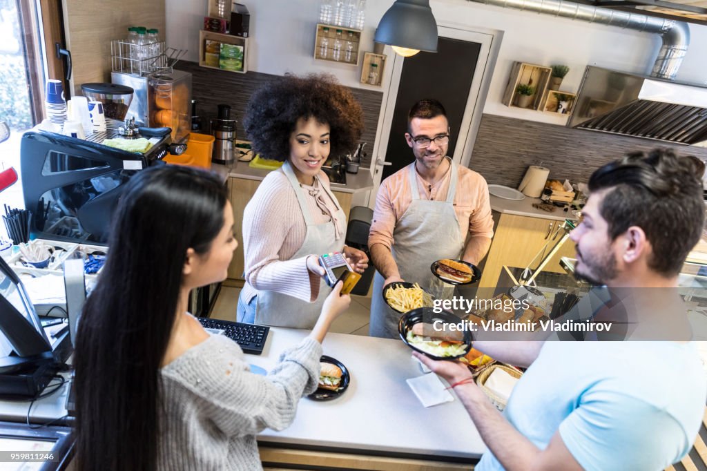 Couple using credit card in fast food restaurant