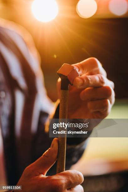 close up of a man rubbing a pool cue with a chalk. - sports chalk stock pictures, royalty-free photos & images