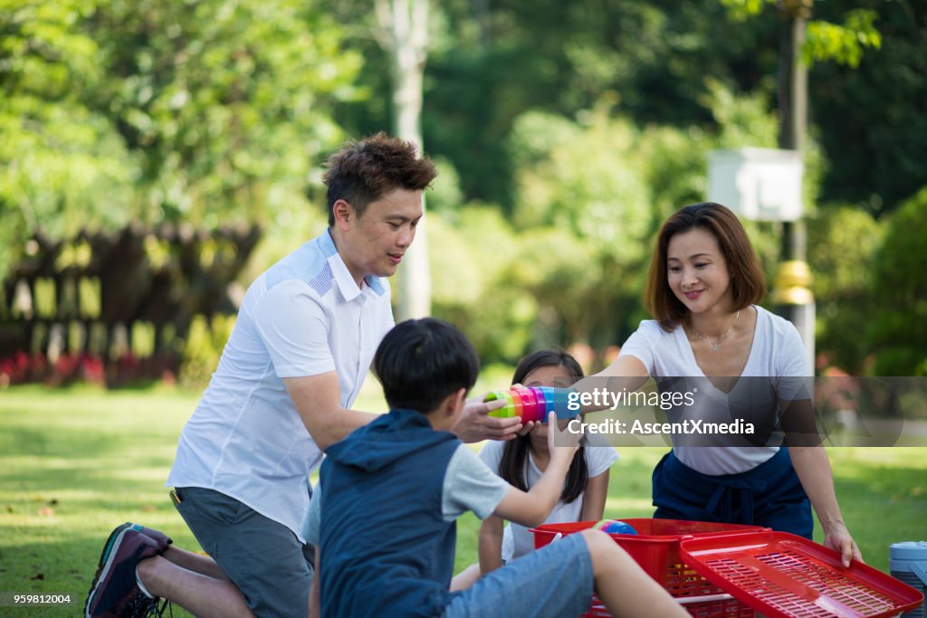 Family setting up a picnic in the park