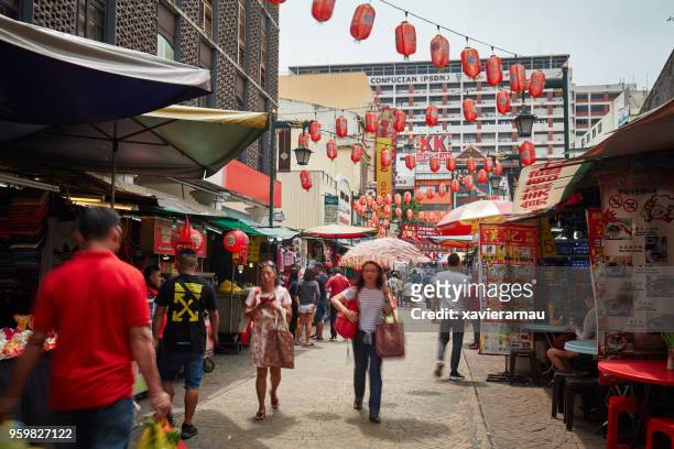 long exposure of people shopping in petaling street, kuala lumpur, malaysia - kuala lumpur street stock pictures, royalty-free photos & images