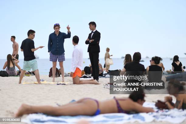 Festival goers relax on the beach on May 18, 2018 during the 71st edition of the Cannes Film Festival in Cannes, southern France.