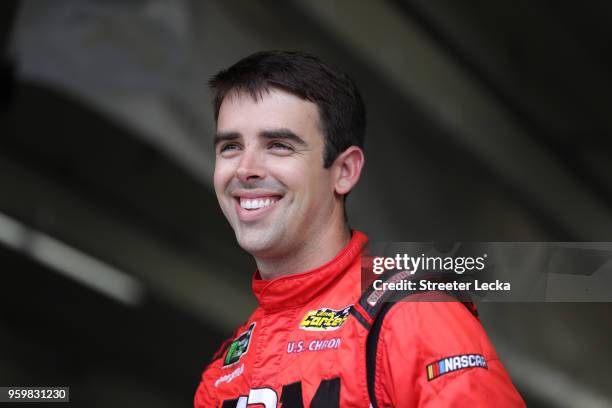 Timmy Hill, driver of the Crossbar E-Cigarettes Chevrolet, stands in the garage during practice for the NASCAR Camping World Truck Series North...