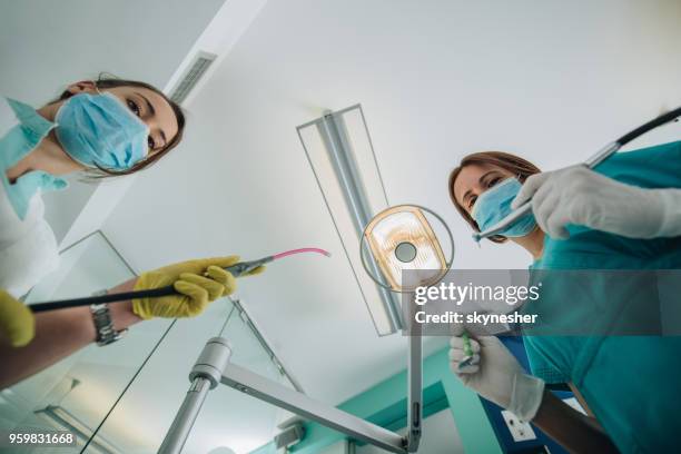 low angle view of two dentists ready for dental examination. - plaque remover stock pictures, royalty-free photos & images