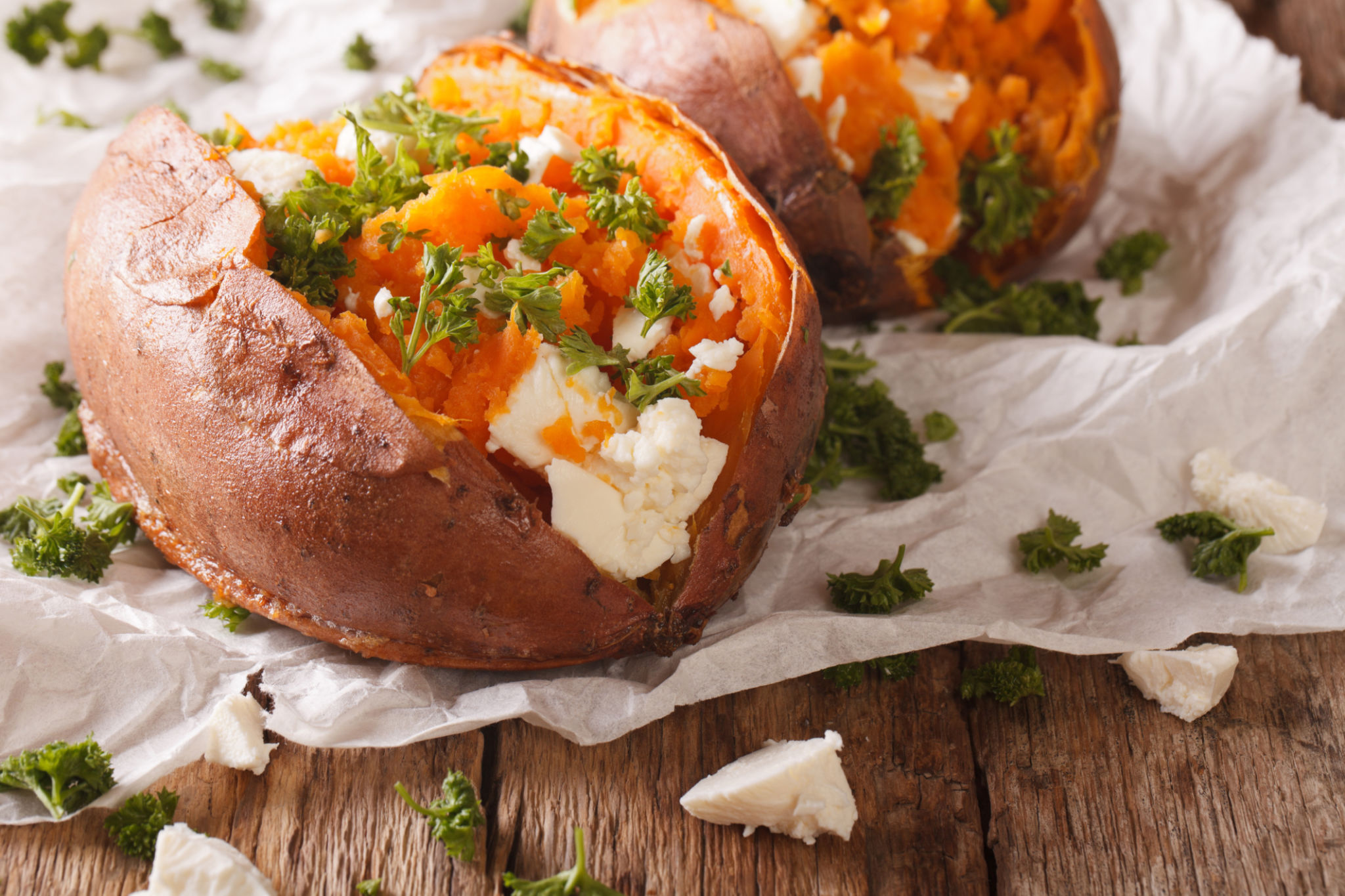 healthy food: baked sweet potato stuffed with cheese and parsley close-up. Horizontal healthy food: baked sweet potato stuffed with cheese and parsley close-up. Horizontal