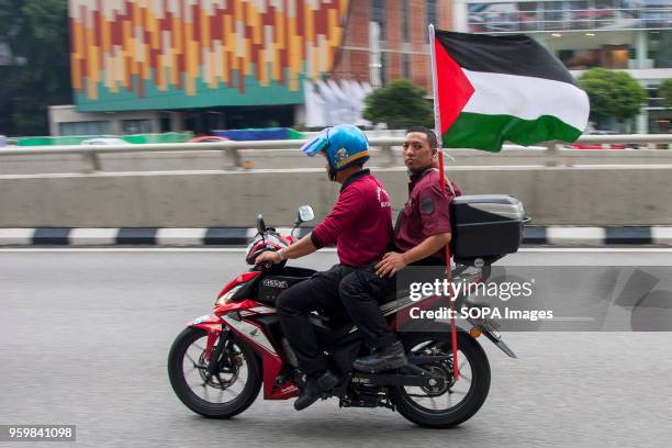 People seen with a Palestine flag at Kuala Lumpur to show their support against the Israel cruelty. Even it is the holy Ramadhan, hundreds of Muslim...