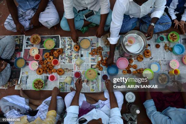 Indian Muslims wait to break their Ramadan fast during the first day of the month of Ramadan at Wallajah Mosque in Chennai on May 18, 2018. - Like...