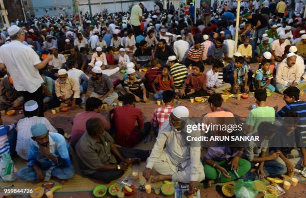 Indian Muslims wait to break their Ramadan fast during the first day of the month of Ramadan at Wallajah Mosque in Chennai on May 18, 2018. - Like...