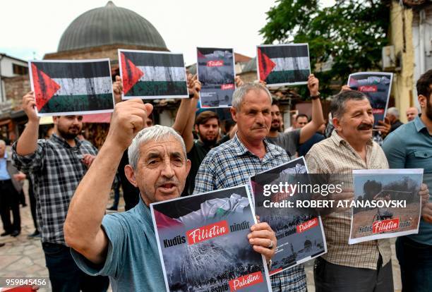 Macedonians Muslim hold placards as they protest to denounce violence against Palestinians in Skopje on May 18, 2018. - A group of Macedonian Muslims...