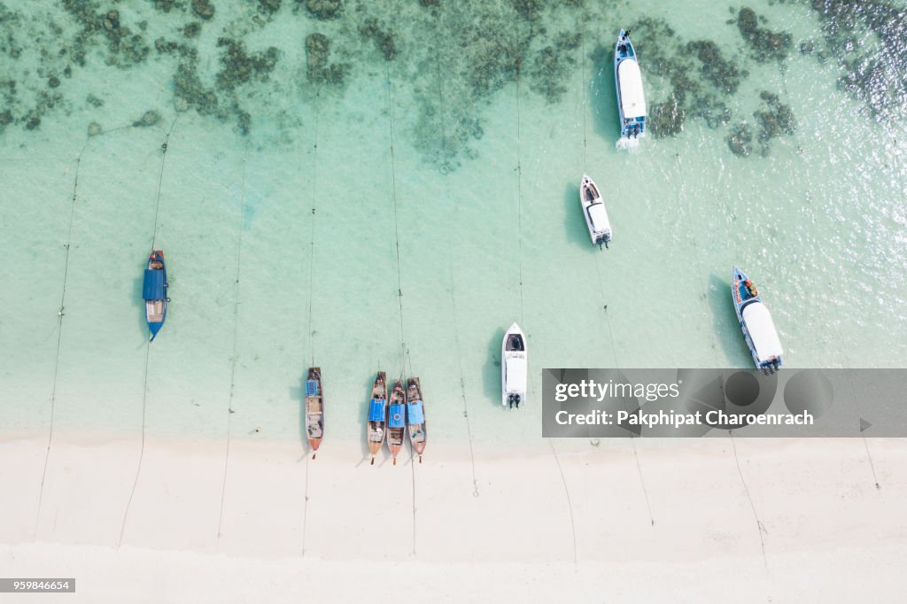 Aerial view of Resorts and boats on tropical white sand at Sunrise Beach, Lipe Island, Thailand.