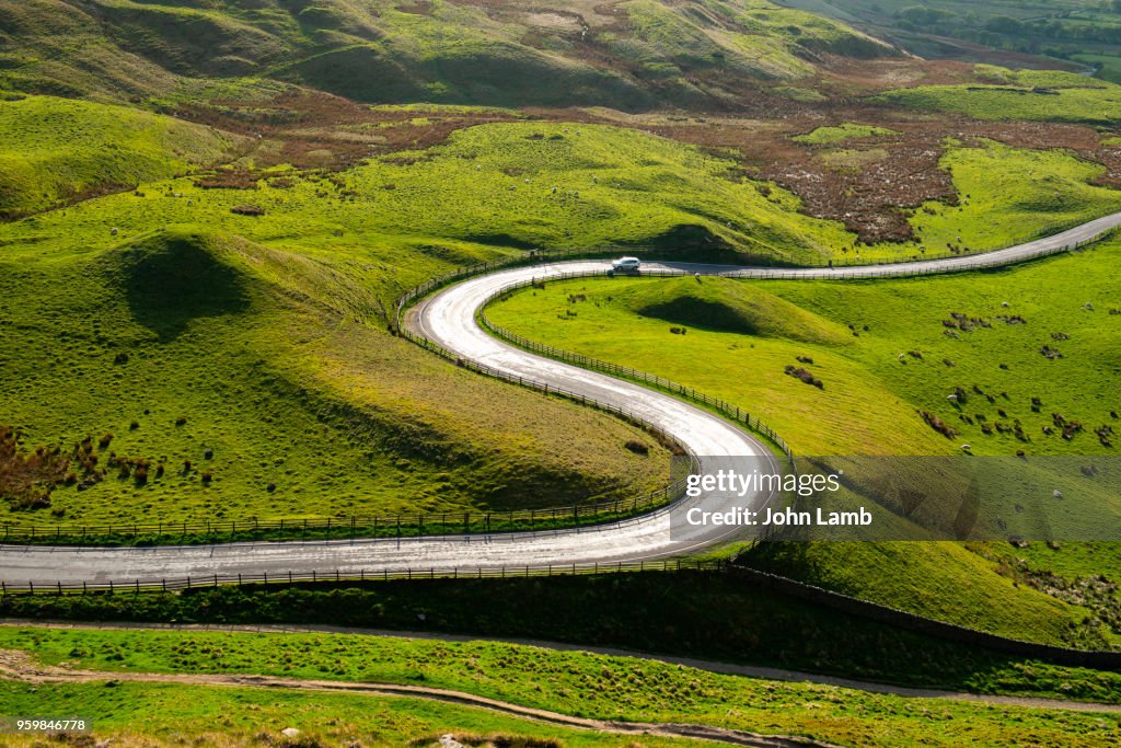 Sun reflecting on sinuous curving road in the English Peak District