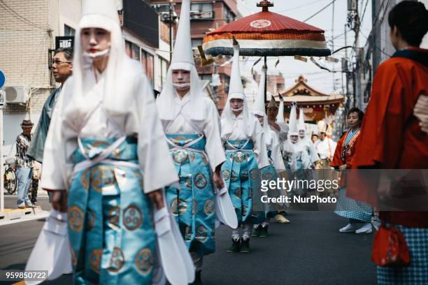 Heron-hooded dancers perform as they parade down the streets toward Asakusa Shrine during Tokyo's one of the largest three day festival called...