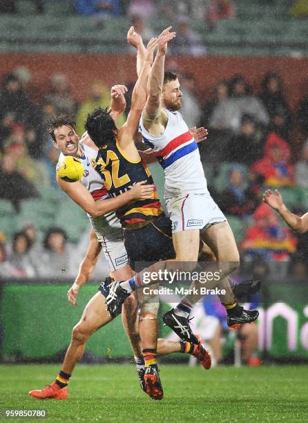 Darcy Fogarty of the Adelaide Crows crashes through Zaine Cody and Jordan Roughead of the Bulldogs during the round nine AFL match between the...