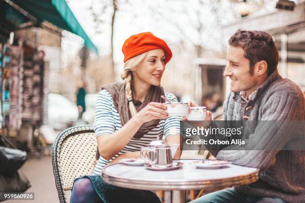 couple having tea in cafe in paris - cafe paris stock pictures, royalty-free photos & images