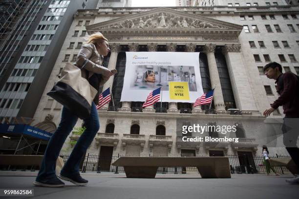 Pedestrians pass a banner displaying Amneal Pharmaceuticals Inc. Signage during the company's listing at the New York Stock Exchange in New York,...