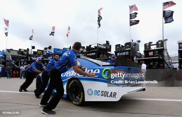 Crew members push the Credit One Bank Chevrolet through the garage during practice for the Monster Energy NASCAR Cup Series All-Star Race at...