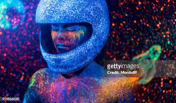 mujer astronauta con maquillaje bizarro neón en el telón de fondo del espacio - female body painting fotografías e imágenes de stock