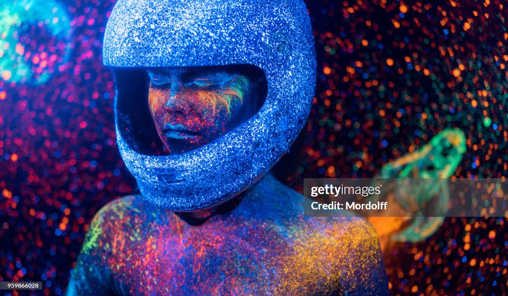 Astronaut Woman with Bizarre Neon Makeup on Space Backdrop