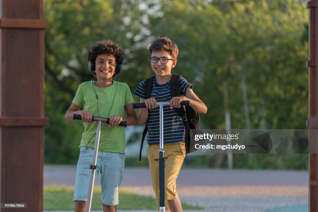 Happy Boys with scooter in a park