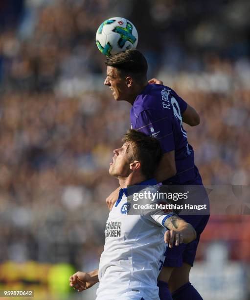 Marvin Pourie of Karlsruhe jumps for a header with Nicolai Rapp of Aue during the 2. Bundesliga Playoff Leg 1 match between Karlsruher SC and...