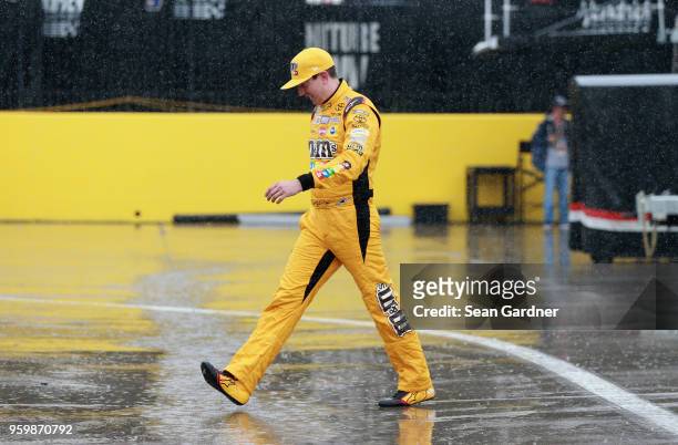 Kyle Busch, driver of the M&M's Red Nose Day Toyota, walks through the garage during a rain delay during practice for the Monster Energy NASCAR Cup...