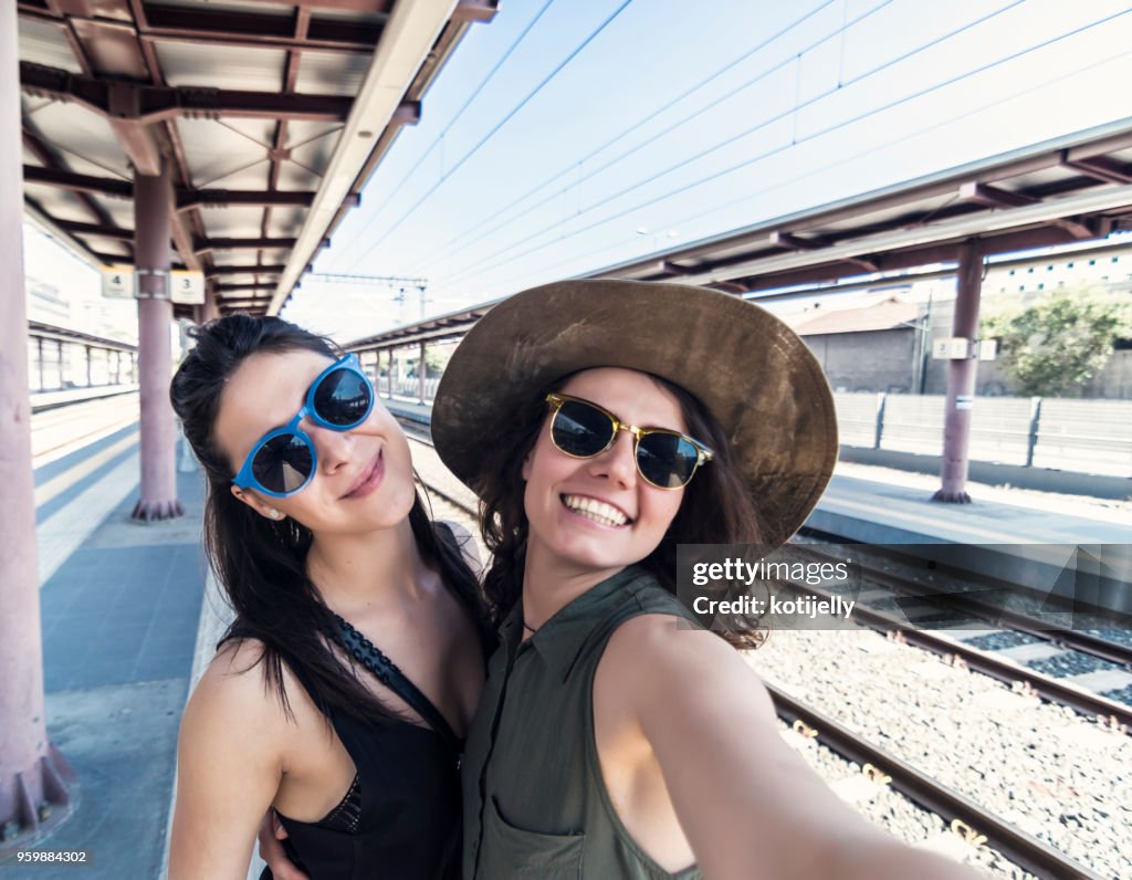Two girlfriends in a train station