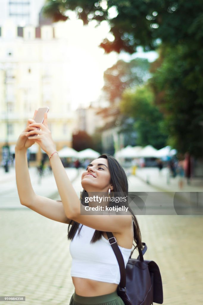 Pretty young woman walking around a city