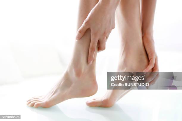 close up of woman rubbing feet - japanese women feet stock pictures, royalty-free photos & images