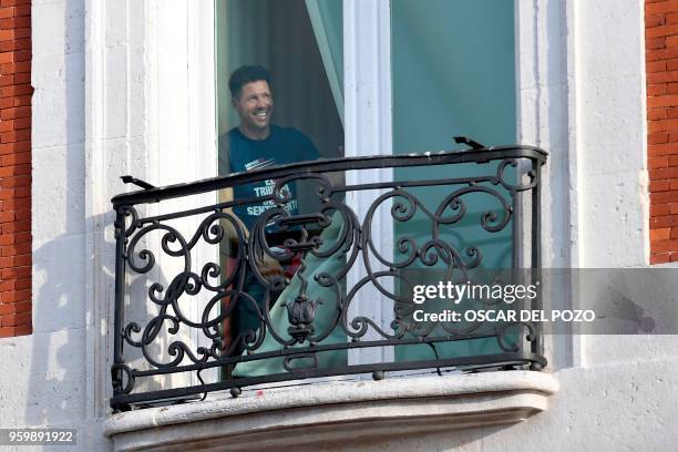 Atletico Madrid's Argentinian coach Diego Simeone looks out a window of the headquarters of the regional government of Madrid as the Spanish club...