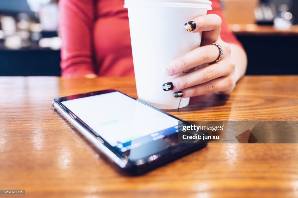 A beautiful girl drinks coffee at a coffee shop in kunming, yunnan province, China.