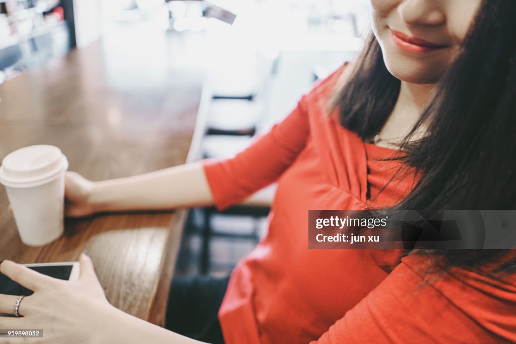 A beautiful girl drinks coffee at a coffee shop in kunming, yunnan province, China.