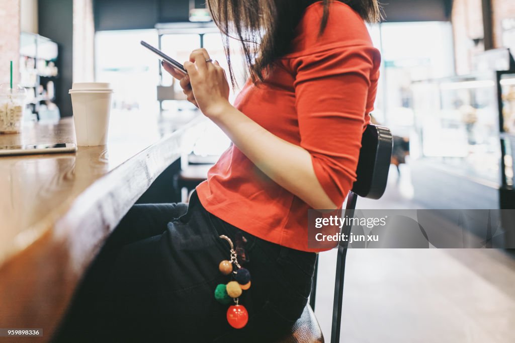 A beautiful girl drinks coffee at a coffee shop in kunming, yunnan province, China.