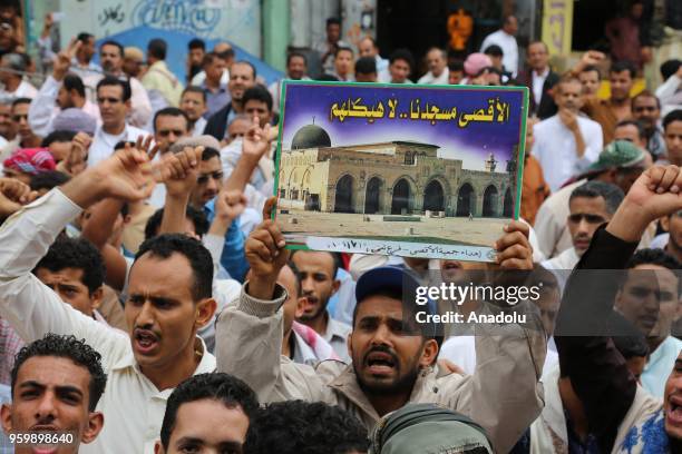 Hundreds of people hold banners and shout slogans as they stage a demonstration to protest against United States' decision to relocate the U.S....