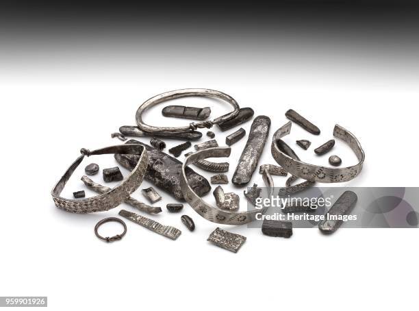 Arm ring, 910. Part of hoard consisting of: penannular arm rings; hammered silver ribbon; zig-zag ornament, rows of punched holes; between circles of...