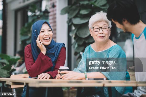 a chinese son introduce his malay girlfriend to his mother for the first time - malayan ethnicity stock pictures, royalty-free photos & images