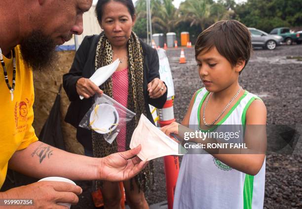 John Freitas hands out dust masks to evacuees of the Leilani Estates subdivision at The Hub in Pahoa, Hawaii on May 17, 2018. - Hawaii's Kilauea...