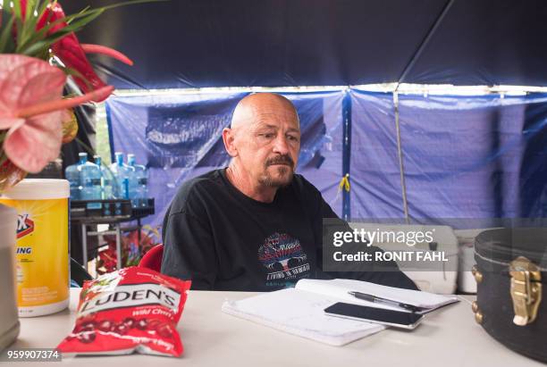 David Hess, Jr., an evacuee from Leilani Estates subdivision,sits at The Hub in Pahoa, Hawaii on May 17, 2018. - Hawaii's Kilauea volcano erupted...