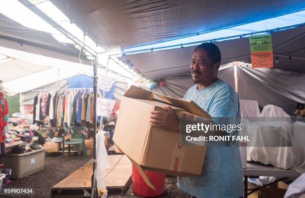 Volunteer holds a donation at The Hub in Pahoa, Hawaii on May 17, 2018. - Hawaii's Kilauea volcano erupted from its summit early May 17 shooting a...