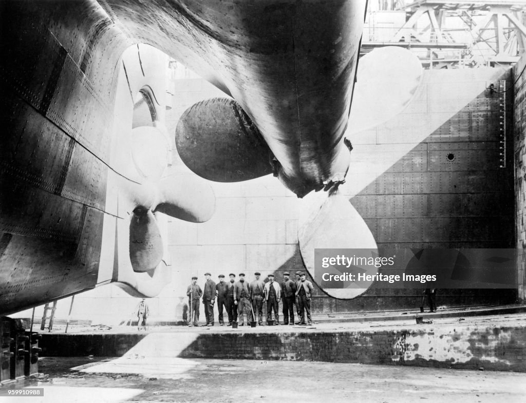 Workmen Standing Under One Of The Propellors Of The Titanic
