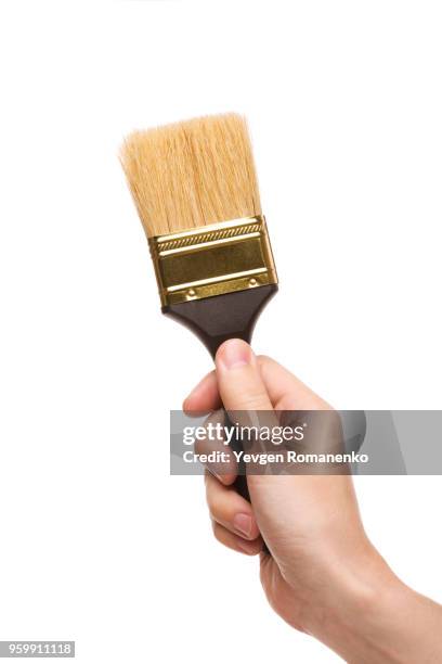 hand with a brush isolated on white background - werkzeug freisteller stock-fotos und bilder