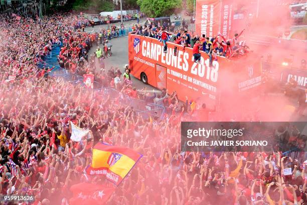 Atletico Madrid's players parade aboard an open-top bus to celebrate their Europa League victory at the Fountain of Neptune in Madrid on May 18, 2018.