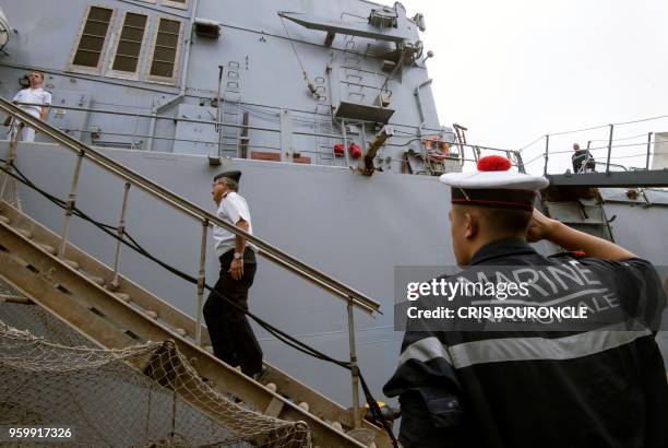 Guard salutes a superior boarding the French navy surveillance frigate Prairial, docked at the naval base in the Peruvian port of Callao on May 18,...