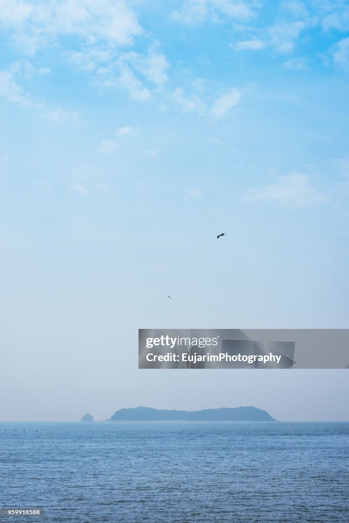 Islands floating on the sea and birds flying on blue sky