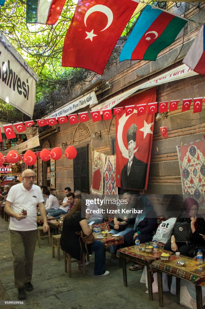 Street café at Kemeralti , turkish flags around and seated customers, Izmir Turkey