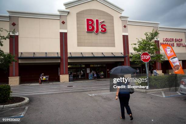 Customer holds an umbrella while walking towards the entrance of a BJ's Wholesale Club Holdings Inc. Location in Miami, Florida, U.S., on Thursday,...